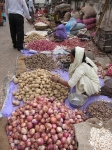 Vendor offering potatoes and onions