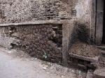 Cowpie patties drying on a wall will be used as fuel